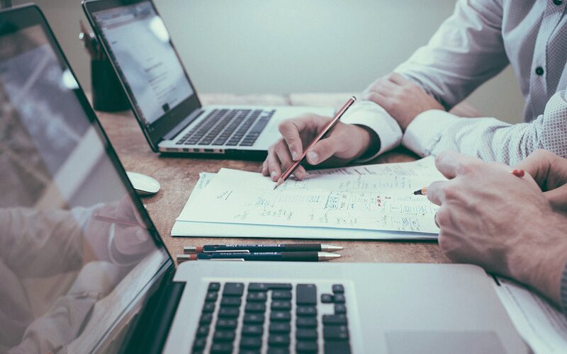 Hiring manager and recruiter planning a search on paper and laptop