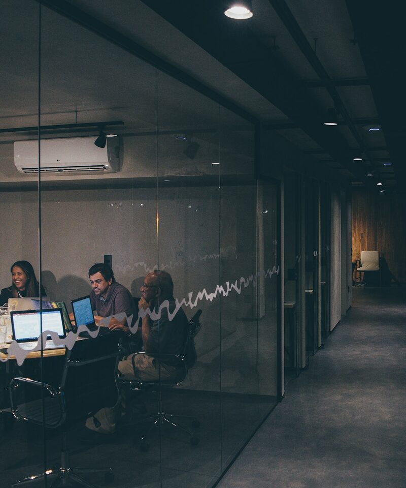 Sales and marketing team meeting in a modern glass-walled Raleigh office